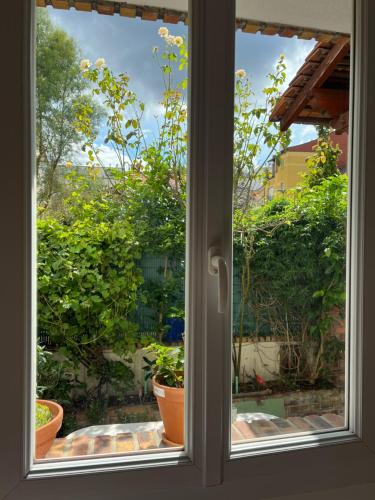 a window with a view of a garden outside at Leo House - Porte de Versailles, Parc des expositions in Issy-les-Moulineaux