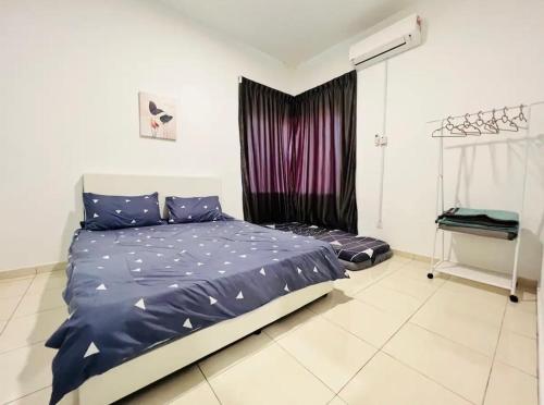 a bedroom with a bed with blue sheets and a window at MoonLight Sweet Home Kuala Selangor 30pax karaoke in Kuala Selangor