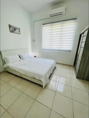 a white bedroom with a bed and a window at MoonLight Sweet Home Kuala Selangor 30pax karaoke in Kuala Selangor