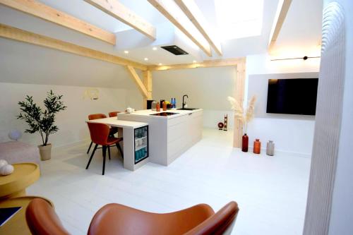 a kitchen with a white counter and red chairs at Apartamenty Blanca in Łeba