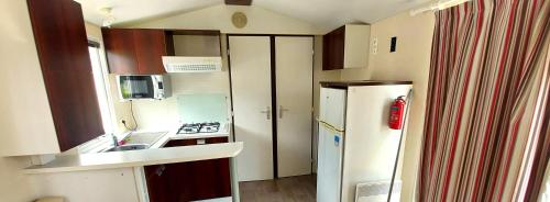 a small kitchen with a refrigerator and a sink at Camping Prima in Týn nad Vltavou