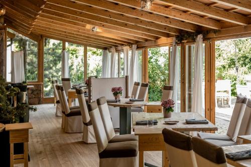 a dining room with a table and chairs and windows at Hotel Bad Schörgau in Sarntal