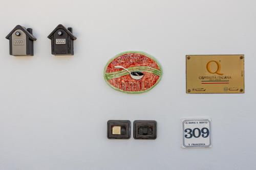 a white wall with a clock and switches and an alarm clock at B&B Il Ramaiolo in Santa Maria a Monte
