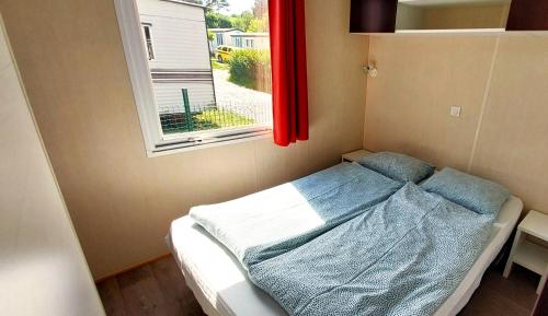 a small bed in a room with a window at Camping Prima in Týn nad Vltavou
