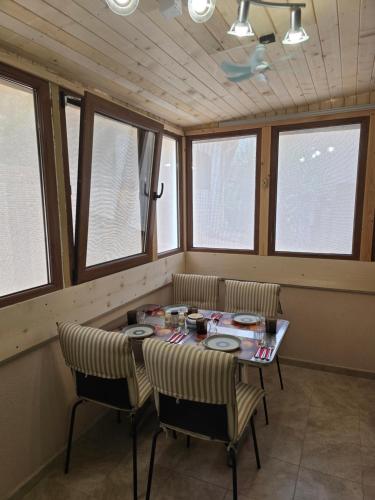 a room with a table and chairs and windows at Апартамент Морската Къща-НЕСТИНАРКА in Tsarevo