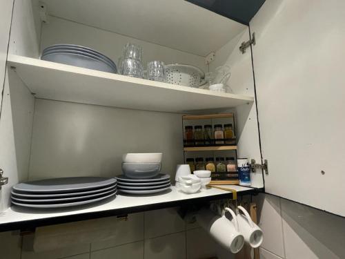 a kitchen with plates and dishes on a shelf at Green Balcony Lille Hyper centre in Lille