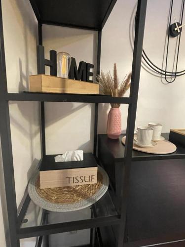 une étagère noire avec une boîte et de la vaisselle dessus dans l'établissement Green Balcony Lille Hyper centre, à Lille