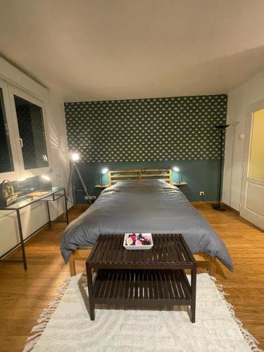 une chambre avec un grand lit et une table dans l'établissement Green Balcony Lille Hyper centre, à Lille