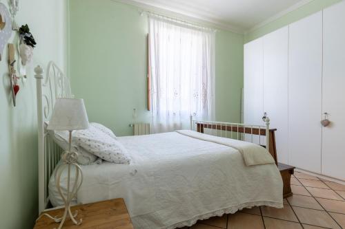 a bedroom with a white bed and a window at B&B Il Ramaiolo in Santa Maria a Monte