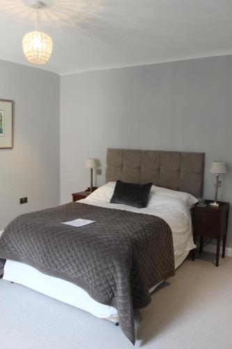 a bedroom with a large bed with a gray blanket at Beautiful farm house with dedicated sitting and media room for guest's use in Charwelton