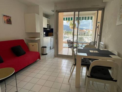 un salon avec un canapé rouge et une table dans l'établissement Appartement studio cabine - Argelès sur mer AR260-206, à Argelès-sur-Mer