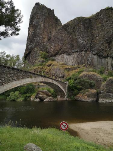 a bridge over a river with a no swimming sign in the water at Maison confortable à Vergezac avec terrasse in Vergezac