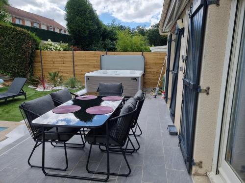 a table and chairs sitting on a patio at Spassionnement pool in Jouy-le-Moutier