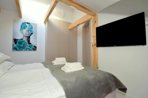 a bedroom with a bed with a flat screen tv at Apartamenty Blanca in Łeba