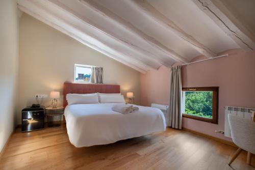 a bedroom with a large white bed and a window at Hotel-Boutique by Gonzalo Sesma in Cervera del Río Alhama