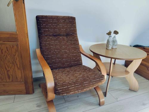 a rattan chair next to a table with a small table at Stary Dom in Kandyty
