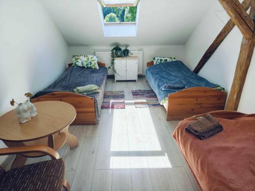a attic room with two beds and a table at Stary Dom in Kandyty