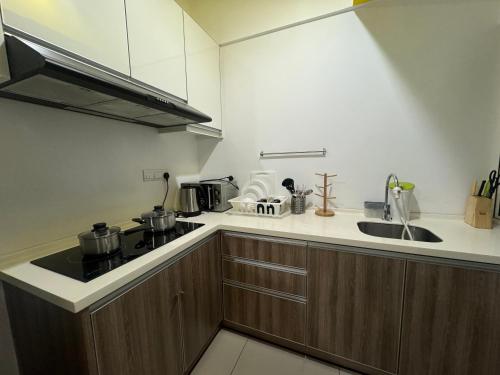 a small kitchen with a stove and a sink at The Majestic Imperial Tower Premium Suite - Ipoh in Ipoh