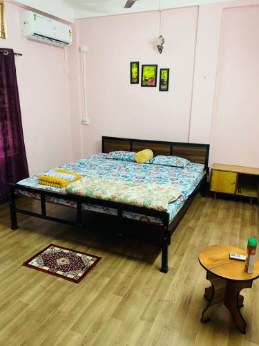 a bedroom with a bed in a room with a table at RESTFUL HEAVEN HOMESTAy in Nunmāti
