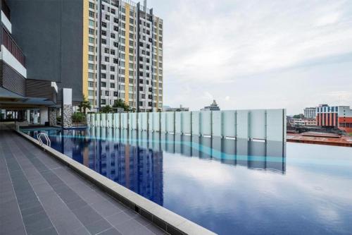 a large swimming pool with a tall building in the background at The Majestic Imperial Tower Premium Suite - Ipoh in Ipoh