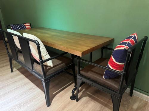 a wooden table and two chairs with pillows on them at The Majestic Imperial Tower Premium Suite - Ipoh in Ipoh