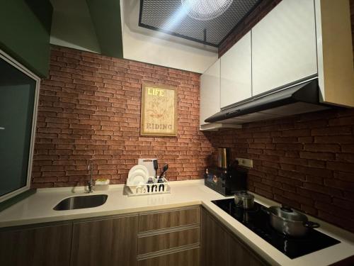 a kitchen with a sink and a brick wall at The Majestic Imperial Tower Premium Suite - Ipoh in Ipoh