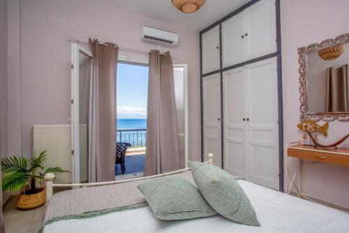 a bedroom with a bed and a view of the ocean at Ionian Kaizer Boutique in Achílleion