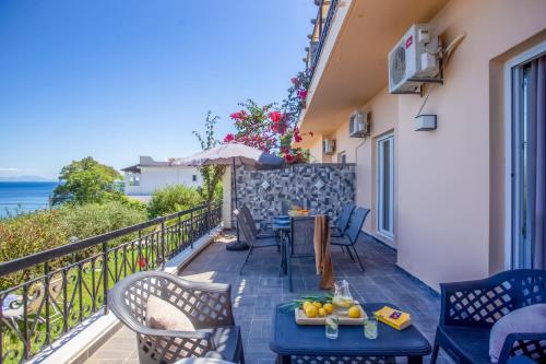 a balcony with tables and chairs and a view of the ocean at Ionian Kaizer Boutique in Achílleion
