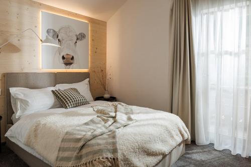 a bedroom with a bed with a picture of a cow on the wall at Eny Guesthouse in Moieciu de Jos