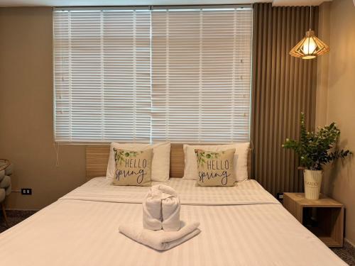a bedroom with a bed with towels on it at The Nine Place แจ้งสนิท in Ban Nong Bua