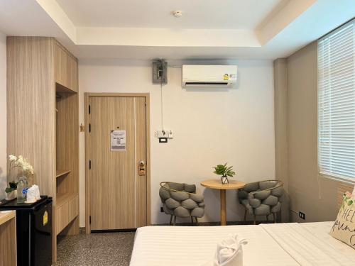 a hotel room with a bed and a table and chairs at The Nine Place แจ้งสนิท in Ban Nong Bua