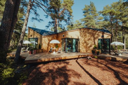 a tiny house in the woods with a deck at Lahepere Villa mini-villad in Kloogaranna