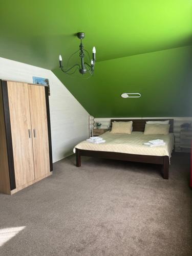a green room with a bed and a green ceiling at Chalet Mlyn in Migovo