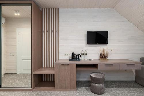a home office with a desk and a tv on a wall at Hotel Podgorie Spa in Bukovel