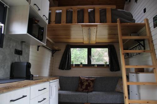 a tiny house with a loft bed and a couch at Farkas-Lak in Mezőcsát