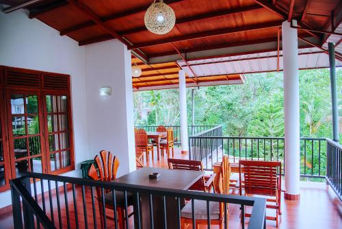 a dining room with a table and chairs on a balcony at Freedom Guest Inn Ella in Ella
