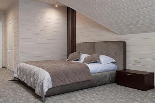 a bedroom with a large bed with a night stand at Hotel Podgorie Spa in Bukovel