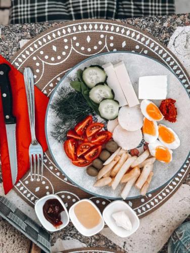 a plate of food with eggs and vegetables on a table at Serenita Stone House in Becici