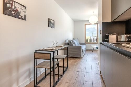 Il comprend une cuisine et un salon avec une table. dans l'établissement Le 202 - Proche telecabine - Vue Montagne, à Saint-Gervais-les-Bains