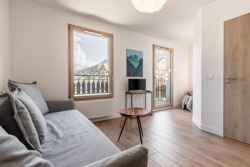 un salon avec un canapé et une fenêtre dans l'établissement Le 202 - Proche telecabine - Vue Montagne, à Saint-Gervais-les-Bains