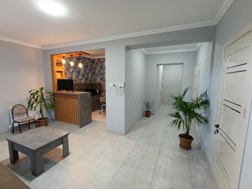 a hallway with a table and plants in a room at VST KHANOYAN'S HOTEL in Ninotsminda