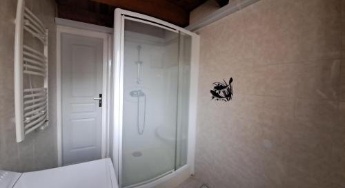 une salle de bain avec une douche et un autocollant de chat noir sur le mur dans l'établissement Studio duplex avec extérieur, à Aigues-Mortes