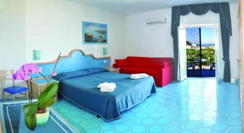 a bedroom with a blue bed and a red couch at Hotel Villa Cimmentorosso in Ischia