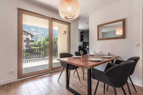 une salle à manger avec une table et des chaises et un balcon dans l'établissement Le 203 - Proche telecabine - centre ville, à Saint-Gervais-les-Bains