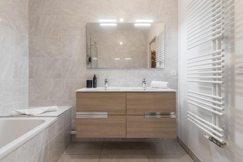 une salle de bain avec un lavabo, une baignoire et un miroir dans l'établissement Le 203 - Proche telecabine - centre ville, à Saint-Gervais-les-Bains