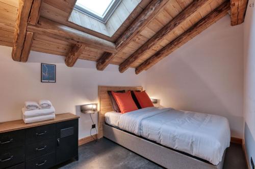 une chambre avec un lit et un plafond en bois dans l'établissement La Pieuca - Calme - Proche centre ville, aux Contamines-Montjoie