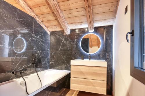 une salle de bain avec une baignoire, un lavabo et un miroir dans l'établissement La Pieuca - Calme - Proche centre ville, aux Contamines-Montjoie