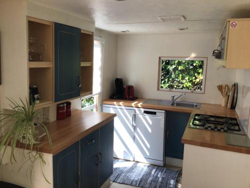 a kitchen with blue cabinets and a sink at Minicamping Hoeve het Tij in Vrouwenpolder