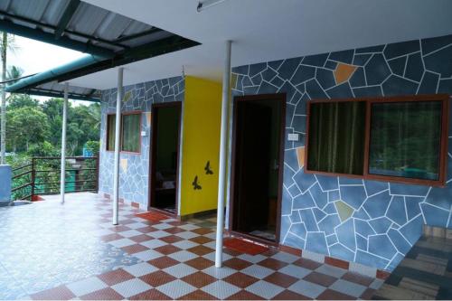 a building with a tiled floor and two doors at Dean Dale Cottages in Thekkady