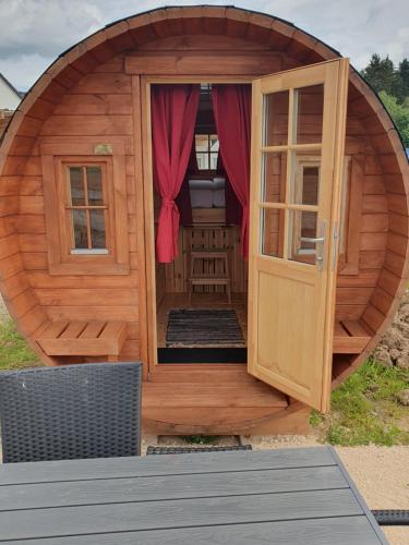 a large wooden circular building with a door and windows at Clamping Schlaffässer im Ferienpark Wolfsschlucht Prüm Eifel in Prüm